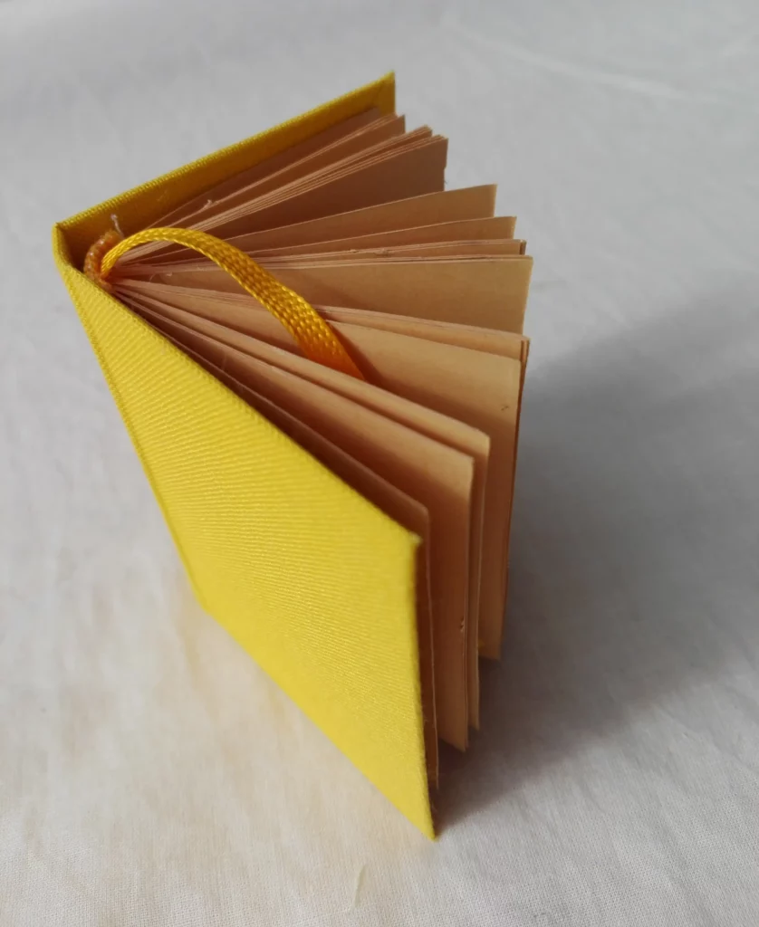 Livre jaune posé debout constitué de papier recyclé